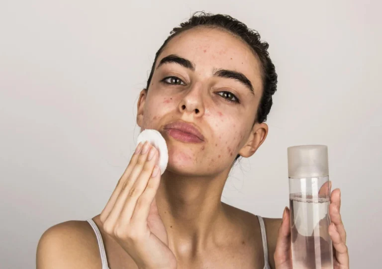 A Woman Wiping Her Face With Cleanser
